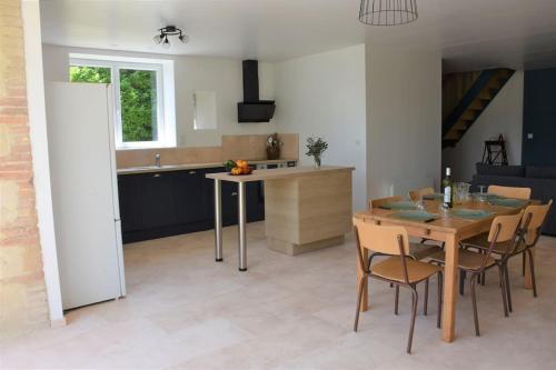 a kitchen and dining room with a table and chairs at Grange Labarthessié in Briatexte