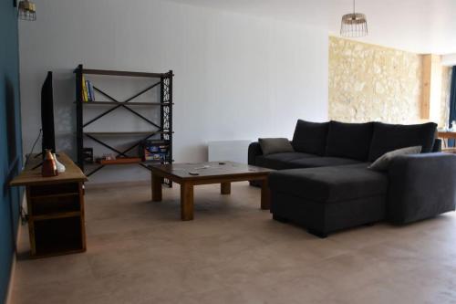 a living room with a couch and a coffee table at Grange Labarthessié in Briatexte