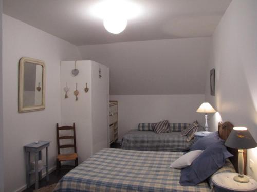 - une chambre avec un lit et une couverture bleue en damier dans l'établissement Le gîte de Mimi, à Vigoux