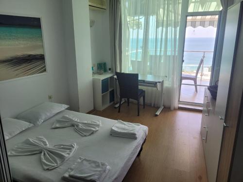 a bedroom with a bed and a desk with a view of the ocean at Silver A28 in Byala