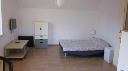 1 dormitorio con 1 cama, armario y mesa en Dom Letniskowy Zuzanna, en Nadole