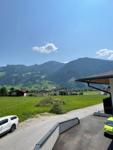 a car parked on a road with mountains in the background at Apart Egger in Schwendau