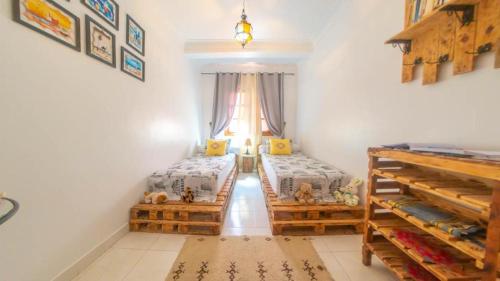 - une chambre avec 2 lits jumeaux et une fenêtre dans l'établissement Appart Ayoub, à Essaouira