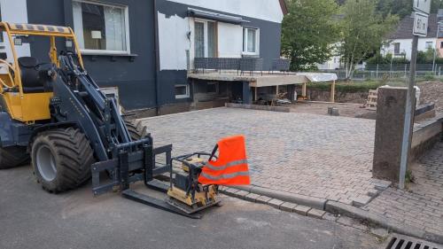 a bulldozer with an orange cone in front of a building at Ferienwohnung Jill Schleiden in Schleiden