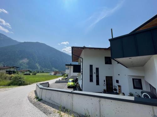 a house with a car parked on the side of a road at Apart Egger in Schwendau
