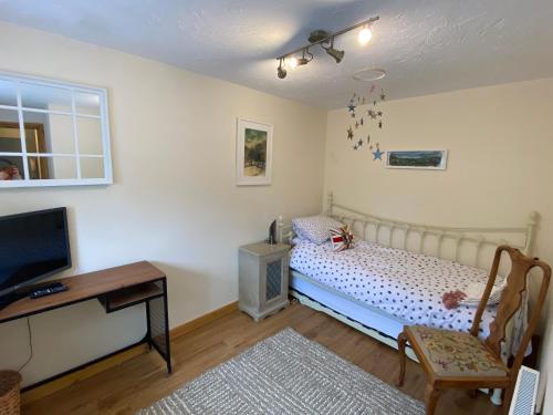 a bedroom with a bed and a desk and a tv at Serendipity in Pateley Bridge