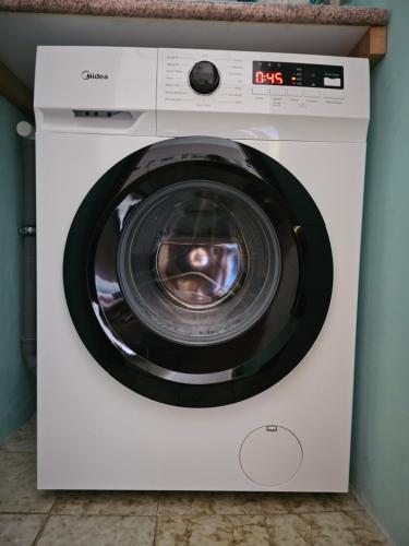 een witte wasmachine met open deur bij Apartman Norma free parking in Rabac