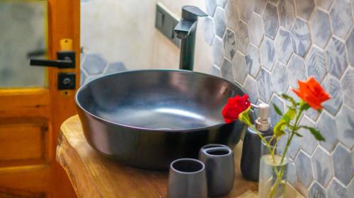 a large metal sink on a wooden counter with flowers at Appart Ayoub in Essaouira