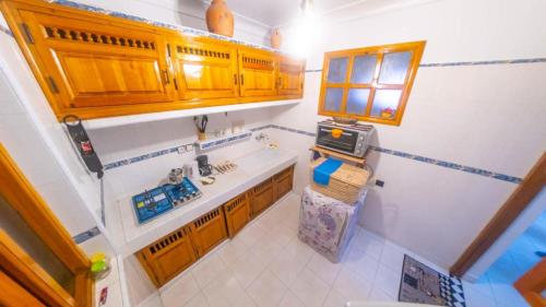 - une vue sur la cuisine avec des placards en bois dans l'établissement Appart Ayoub, à Essaouira