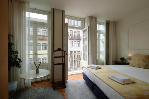 Impar Luxury Apartments في بورتو: غرفة نوم بسرير وطاولة ونوافذ