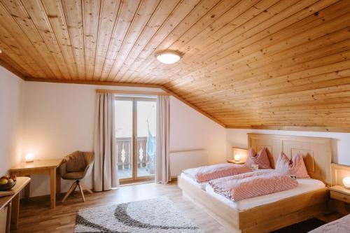ein Schlafzimmer mit zwei Betten und einer Holzdecke in der Unterkunft Feichtingerhof in Steinbach am Attersee
