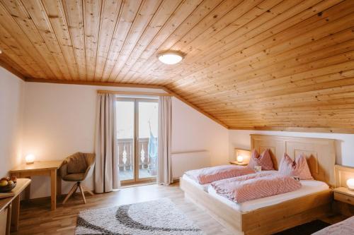 een slaapkamer met 2 bedden en een houten plafond bij Feichtingerhof in Steinbach am Attersee