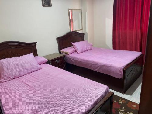- 2 lits dans une chambre avec des draps violets dans l'établissement Chalet at Lasirena Mini Egypt Resort Ein Elsokhna Families Only, à Ain Sokhna