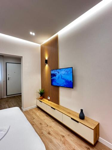 1 dormitorio con TV de pantalla plana en la pared en Beach Apartaments Durres, en Durrës