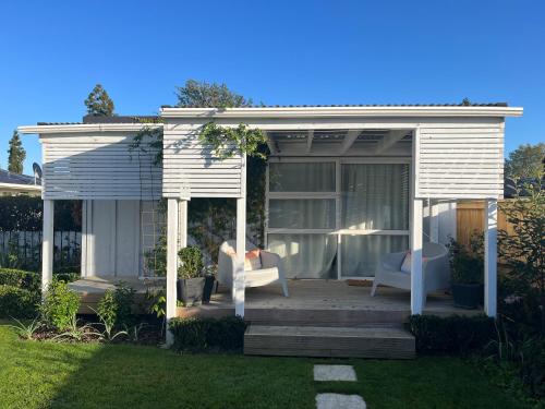 a white gazebo with two chairs on a lawn at Boutique French Central Matamata in Matamata