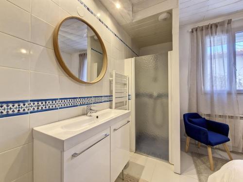 Baño blanco con lavabo y espejo en Maison au coeur d’Arcangues, proximité de Biarritz, en Arcangues