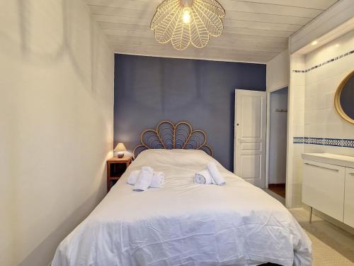 a bedroom with a white bed with towels on it at Maison au coeur d’Arcangues, proximité de Biarritz in Arcangues