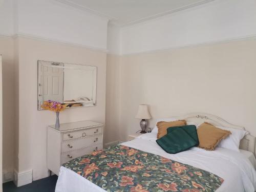 een slaapkamer met een bed, een dressoir en een spiegel bij Single Bedroom available - Train station London Seven Kings in Seven Kings