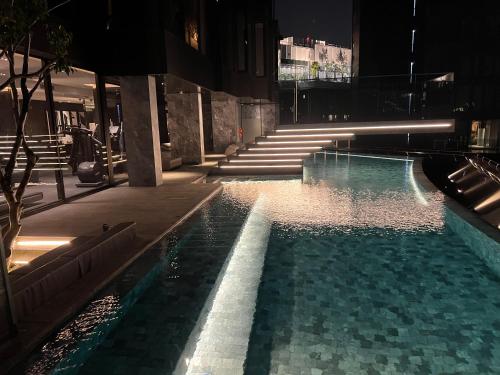 basen z oświetleniem w budynku w nocy w obiekcie 曼谷新火车头夜市高端奢华公寓 w mieście Bangkok