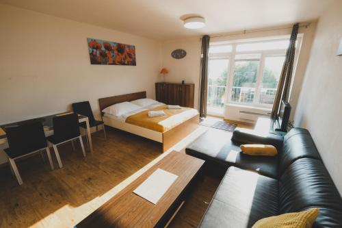 uma sala de estar com uma cama e um sofá em Apartmán Max Lipno em Lipno nad Vltavou