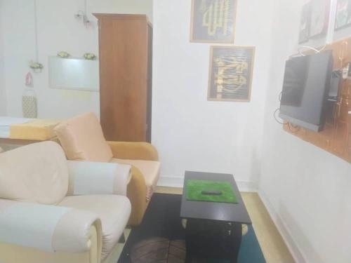 a living room with a couch and a table and a tv at Rumah Tamu FieSari Jeli M U S L I M in Jeli
