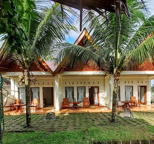 武吉拉旺的住宿－Sumatra Expedition Lodge，两棵棕榈树在房子前面