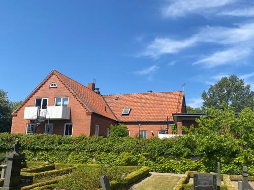 a red brick house with a garden in front of it at Bed and books på Österlens Gästhärbärge in Glemminge