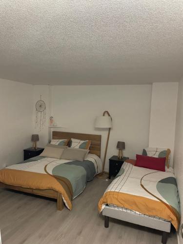 une chambre avec deux lits et deux lampes dans l'établissement À deux pas de la plage du Fogeo Arzon, à Arzon