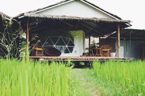 ein Haus mit einer Veranda und Stühlen im Hof in der Unterkunft สะปันดีวิว Sapan Dee View บ่อเกลือ น่าน in Ban Huai Ti