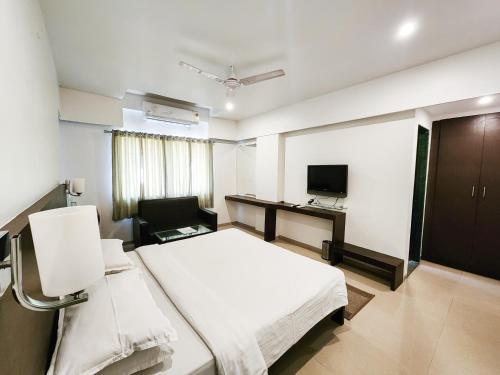 Habitación hospitalaria con cama y escritorio en Hotel Rajwada Aurangabad, en Aurangabad