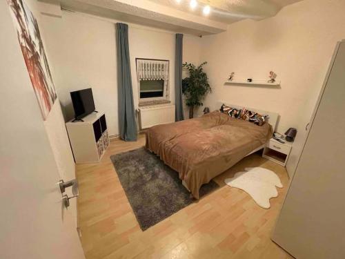 1 dormitorio con 1 cama y TV en RobinsHomes-2023-Frisch renoviert in BS-Lehndorf, en Brunswick