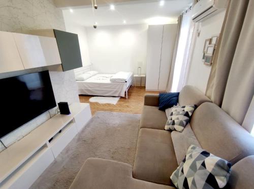 uma sala de estar com um sofá e uma televisão de ecrã plano em Memo Moscavide Guest House em Lisboa