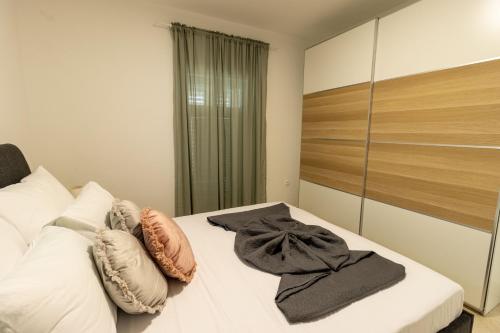 a bedroom with a bed with pillows and a mirror at LUXURY STYLISH APARTMENT BURE in Murter