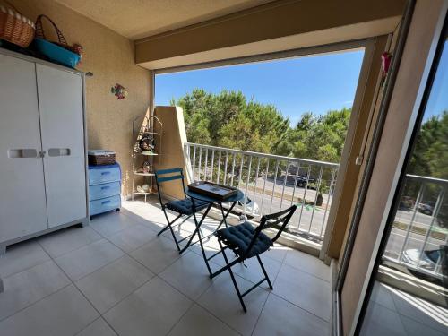 un balcon avec deux chaises et une grande fenêtre dans l'établissement Plage Studio 5 personnes St cyprien 66750, à Saint-Cyprien