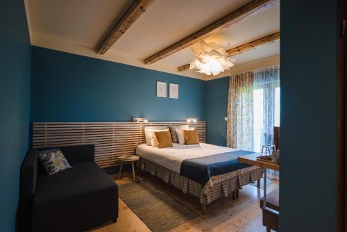 a blue bedroom with a bed and a chair at La Mesteceni & Loc cu Stări de Bine, SPA adult only in Sălicea