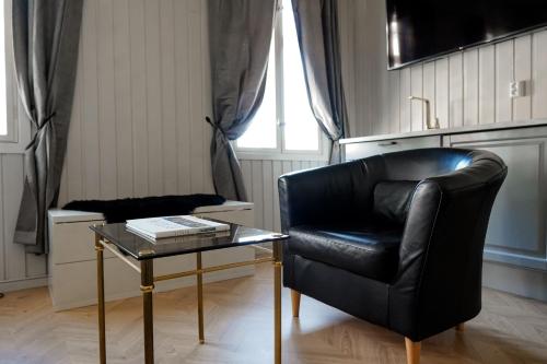 a black leather chair and a table in a room at VILLA BRATTHOLMEN in Brattholmen