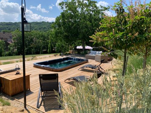 - une piscine sur une terrasse en bois avec des chaises dans l'établissement Villa Emma, à Mavilly-Mandelot