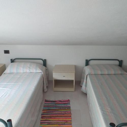 a room with two beds and a table with a rug at Villa Silvana in Terra Mala
