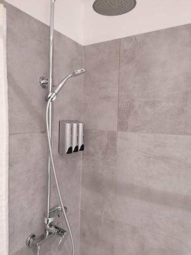 une douche avec une porte vitrée dans une salle de bain dans l'établissement A l'ombre de l'Olivier, à LʼIsle-sur-la-Sorgue