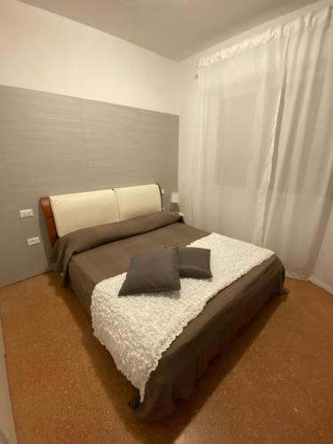 a bedroom with a bed with a pillow on it at APPARTAMENTO MARANGA in Lignano Sabbiadoro