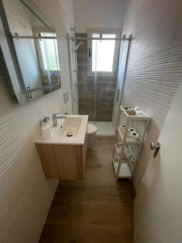 a bathroom with a sink and a toilet and a mirror at APPARTAMENTO MARANGA in Lignano Sabbiadoro