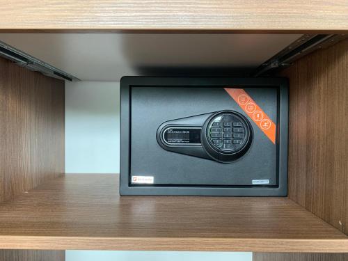 a television with a remote control on a shelf at Park Apartments in Druskininkai