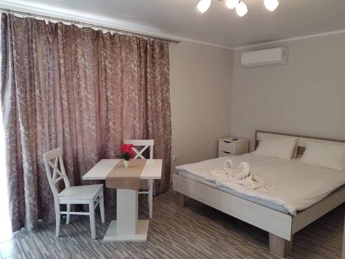 a bedroom with a bed and a desk and a table at Studio SeaDream in Primorsko