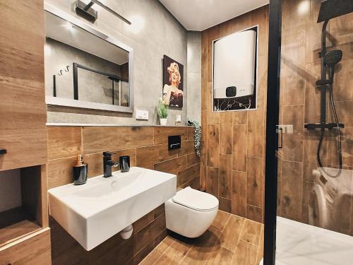 a bathroom with a white sink and a toilet at Apartament Świerkowy in Karpacz