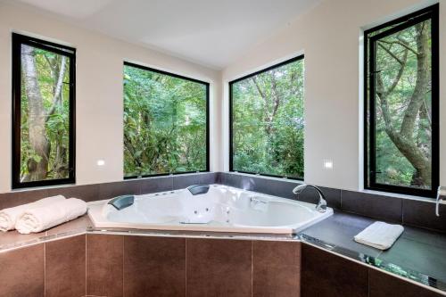 a bath tub in a bathroom with large windows at Millton Park Estate in Invercargill