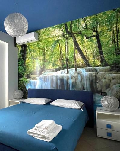 a bedroom with a waterfall mural on the wall at B&B Le Principesse in Rossano Stazione