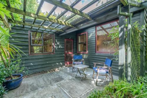 a patio with blue chairs and a pergola at Millton Park Estate in Invercargill