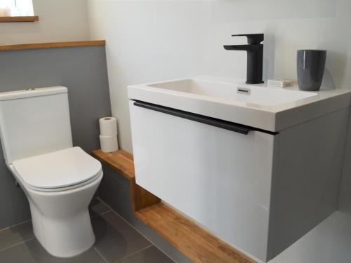 uma casa de banho com um lavatório branco e um WC. em Pass the Keys Spacious modern lovely bungalow em Bournemouth