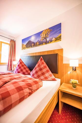 a hotel room with a bed and a table at Pension Gimpl, Chiemgaukarte neu in Siegsdorf