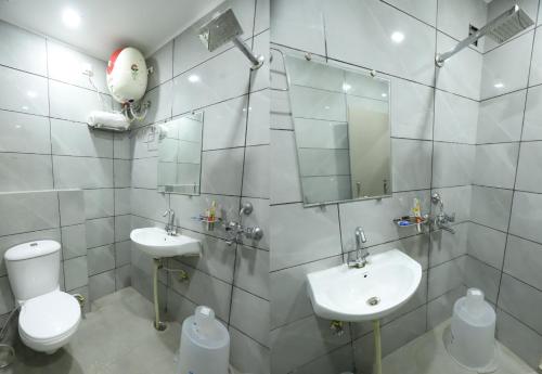 a white bathroom with a toilet and a sink at Heaven Hotel in Bareilly
